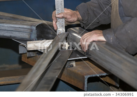 Metalworking shop workers work behind machines and Metalworking shop workers work behind machines and 34306991