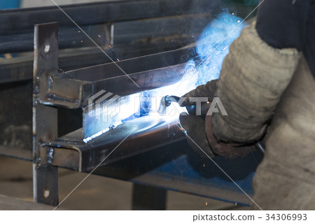 Metalworking shop workers work behind machines and Metalworking shop workers work behind machines and 34306993