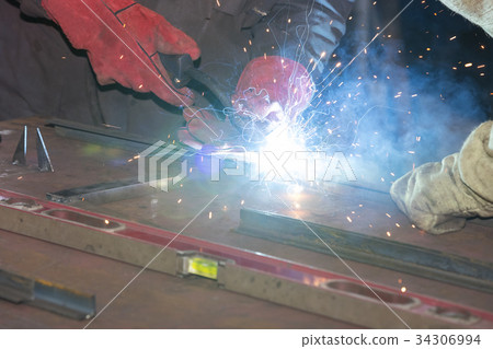 Metalworking shop workers work behind machines and Metalworking shop workers work behind machines and 34306994
