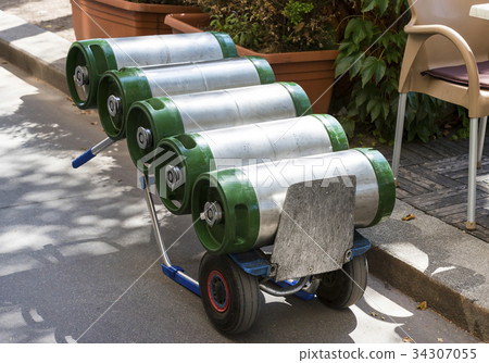 A cart loaded with kegs and beer on a city street  34307055