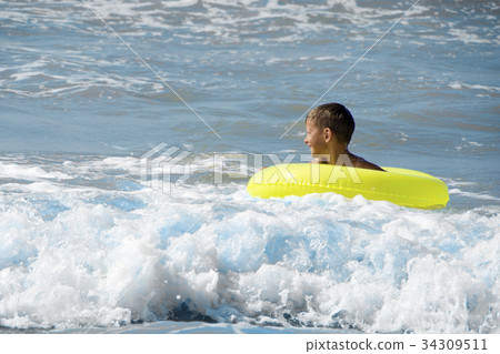 Happy child playing in blue water of sea Happy child playing in blue water of sea 34309511