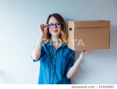 woman in jeans shirt standing on white wall  34309682