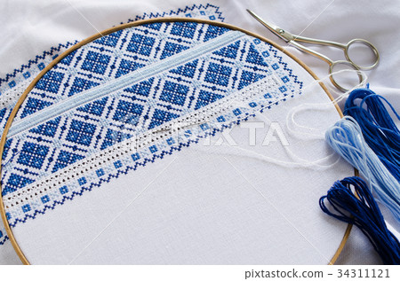 Handmade embroidery by white and blue threads. Handmade embroidery by white and blue threads. 34311121