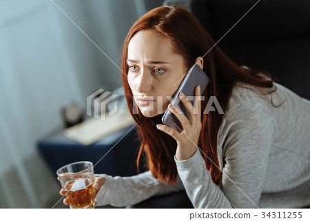 Cheerless gloomy woman making a call Cheerless gloomy woman making a call 34311255