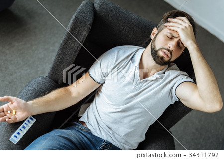Unhappy depressed man suffering from strong pain Unhappy depressed man suffering from strong pain 34311792