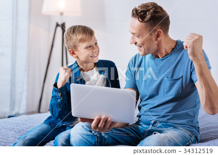 Lively father and son celebrating victory while 34312519