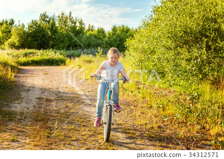 Smiling little girl on a bicycle 34312571