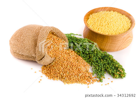 Millet in a wooden bowl, burlap bag and green 34312692