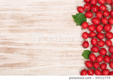 Hawthorn berry with leaves on a white wooden 34312779