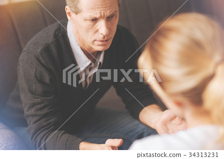 Cheerless adult man visiting a psychologist 34313231