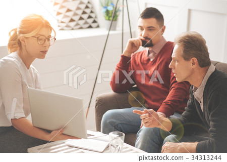 Serious smart woman holding a laptop Serious smart woman holding a laptop 34313244