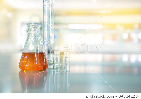 orange liquid in glass flask in lab 34314128