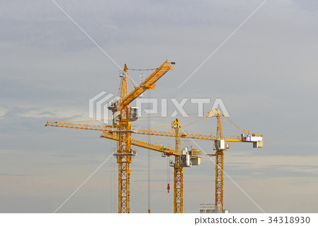 Yellow lifting cranes prepare to start evening 34318930
