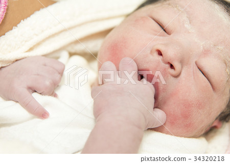 Newborn baby doing finger sucking Newborn baby doing finger sucking 34320218