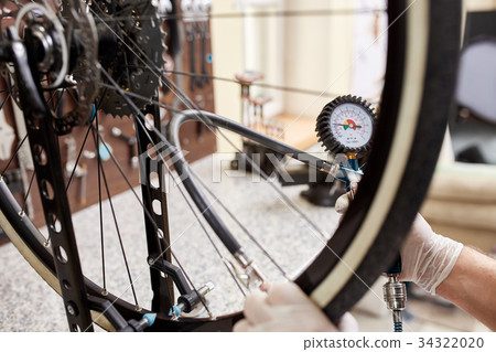 Mechanic repairing a mountain bike in a workshop 34322020