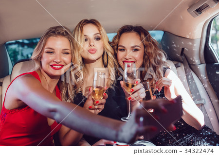 Pretty women having party in a limousine car 34322474