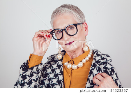 Stylish and elegant old woman in glasses on a Stylish and elegant old woman in glasses on a 34323267
