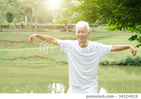 Old man practicing qigong in the park Old man practicing qigong in the park 34324928