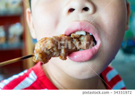 the boy are eating pork grill 34331972