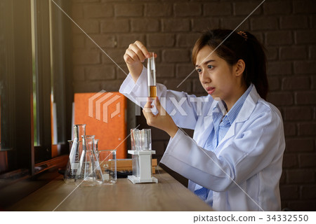 woman scientist checking brown chemical liquid  34332550