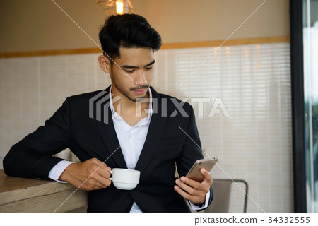 businessman using smartphone during coffee time 34332555