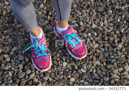 pink sports shoes on gravel 34332771