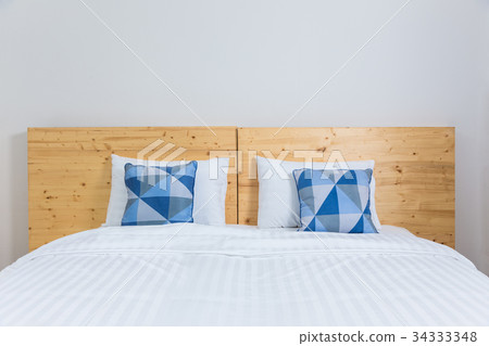 empty white bed with blue and white pillows 34333348