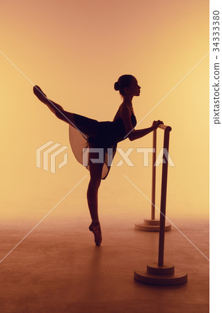 The young ballerina stretching on the bar The young ballerina stretching on the bar 34333380