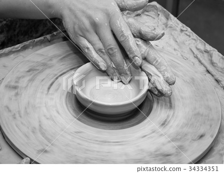 Woman hands in clay at process of making clay bowl 34334351