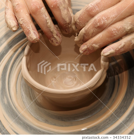 Woman in process of making clay bowl on pottery 34334352