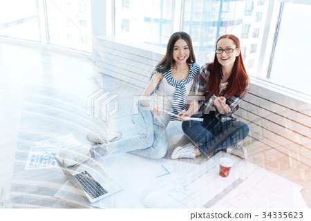 Pleasant women surrounded by schemes and drawings Pleasant women surrounded by schemes and drawings 34335623