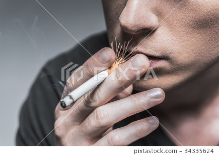Guy inhaling smoke of harmful cigar Guy inhaling smoke of harmful cigar 34335624