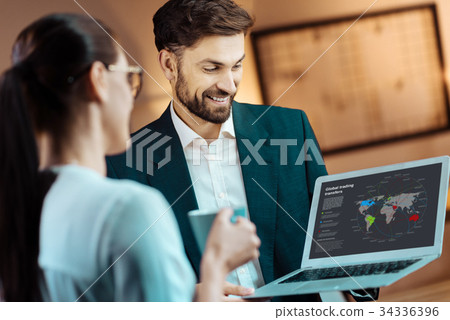 Smiling brunette male holding his laptop Smiling brunette male holding his laptop 34336396