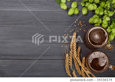 glass of foamy beer with hop cones and wheat on glass of foamy beer with hop cones and wheat on 34336574