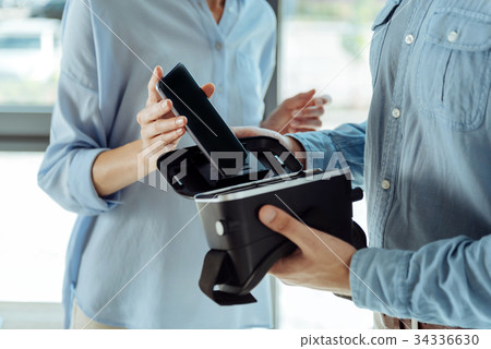 Female specialist removing smartphone from VR 34336630