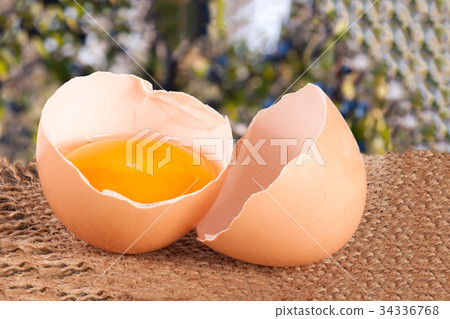 Broken egg with yolk and eggshell On a wooden 34336768