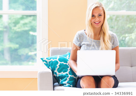 Happy young woman using her laptop 34336991