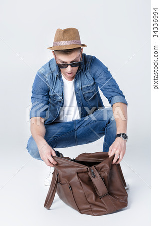 surprised man in a hat looks in an empty leather 34336994