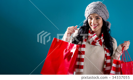 Happy young woman holding shopping bags Happy young woman holding shopping bags 34337055