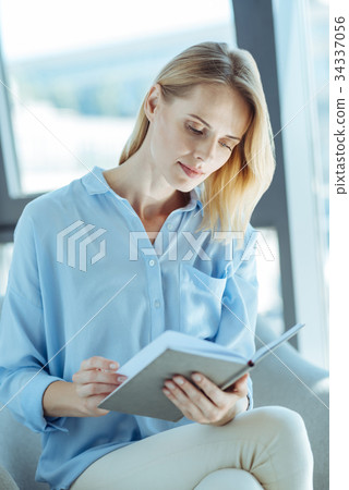 Beautiful young woman reading a book on sofa Beautiful young woman reading a book on sofa 34337056