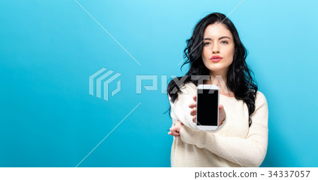 Young woman holding out a cellphone Young woman holding out a cellphone 34337057