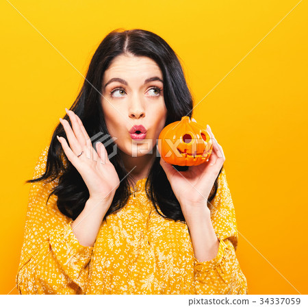 Young woman holding a pumpkin Young woman holding a pumpkin 34337059