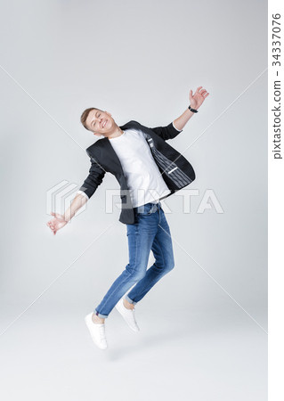 handsome man in jeans and jacket jumping 34337076