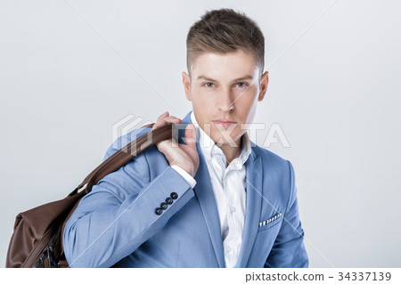 fashion young man in blue suit carrying leather fashion young man in blue suit carrying leather 34337139