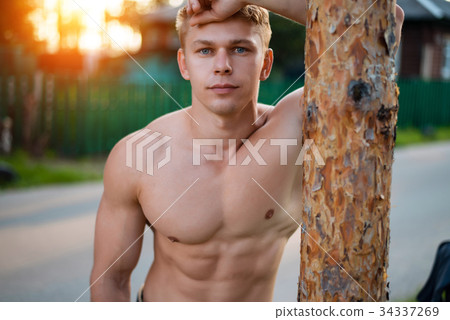 Model male athlete standing park by tree, resting 34337269