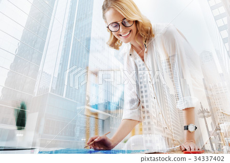 Delighted designer working with sketches Delighted designer working with sketches 34337402