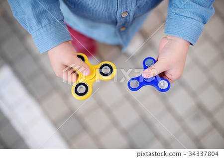 preschooler boy holding rotating fidget spinners preschooler boy holding rotating fidget spinners 34337804