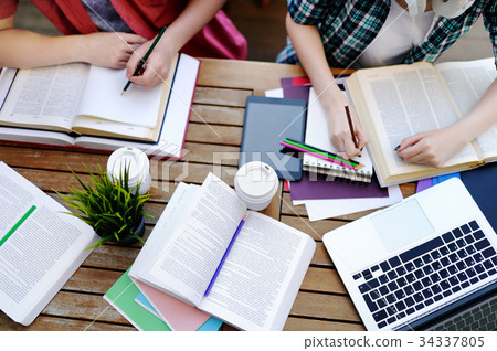 Top view of young students with books and notes Top view of young students with books and notes 34337805