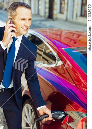 Smart nice businessman talking a fuel nozzle out 34338070