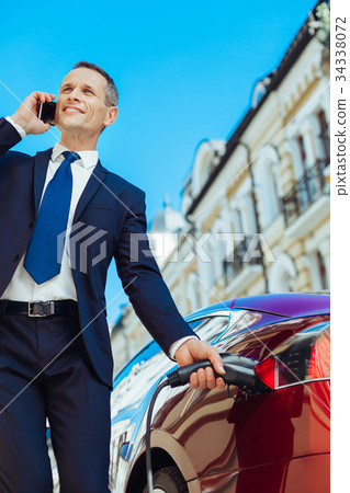 Delighted busy man having a phone conversation 34338072